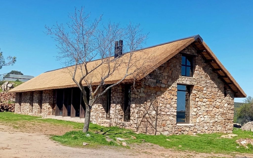Cape Reed International thatched roof installation on a natural stone lodge nestled into the hillside of the Sierra Morena mountains, Spain
