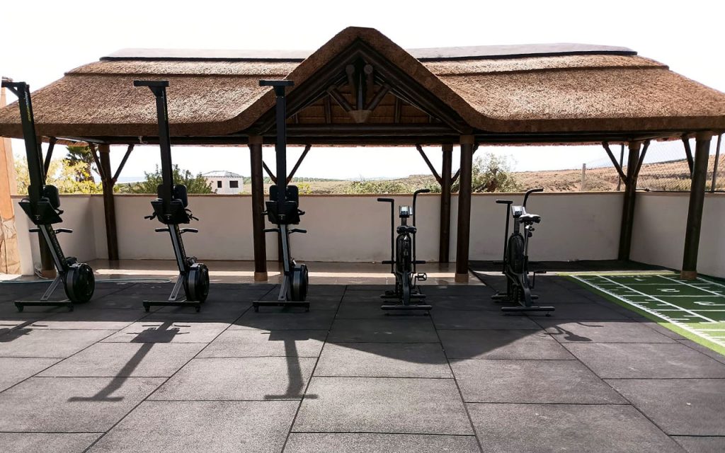 Outdoor fitness training area with bespoke timber and thatch shade structure on Costa Blanca