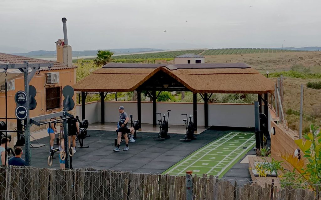 Custom-built thatched pavilion beside outdoor gym at CrossFinca wellness retreat in Spain