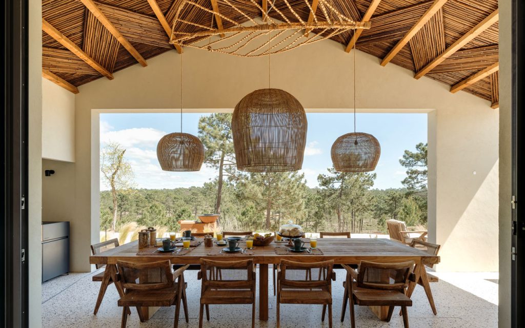 Reed lath vaulted ceiling with three rattan pendant lamps above a timber dining table, Villa Stark outdoor terrace, Comporta